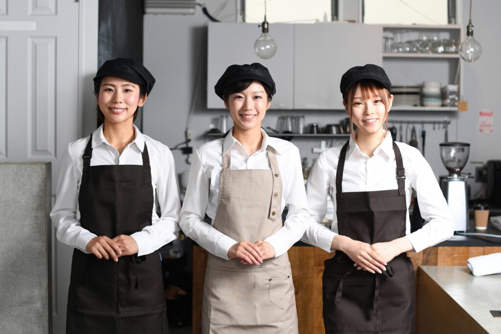 カフェの女性店員3人が笑顔で並んでいる集合写真。記事の最終まとめセクションの画像。