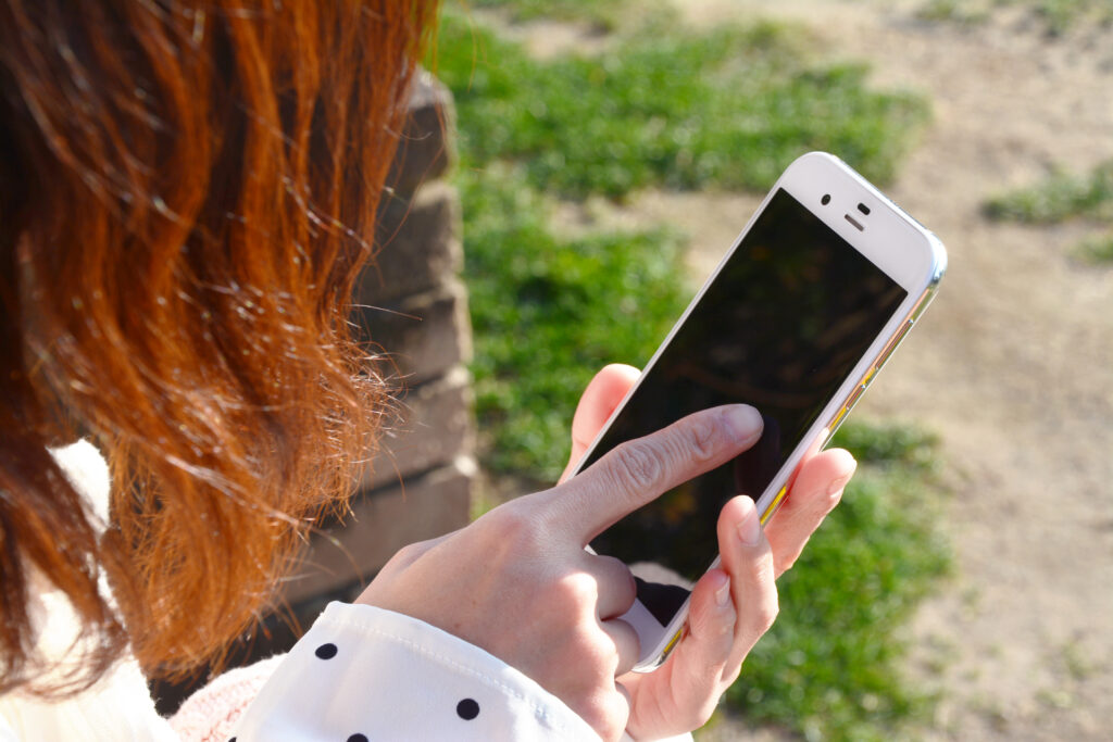 シェアフルは高校生不可？バイト探しの前に利用条件を確認。スマホでアプリを操作している女性の写真。